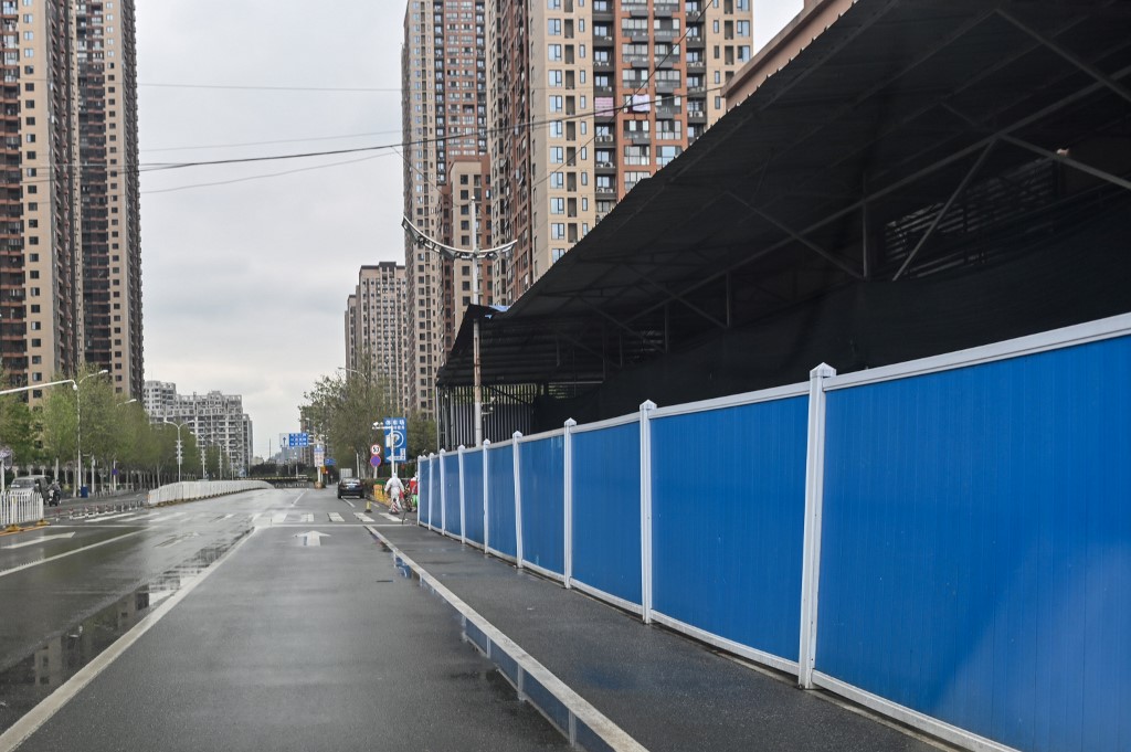 General view of Huanan Seafood Wholesale Market covered by blue fences in Wuhan, in China's central Hubei province on March 30, 2020, after travel restrictions into the city were eased following more than two months of lockdown due to the COVID-19 coronavirus outbreak. - Wuhan, the central Chinese city where the coronavirus first emerged last year, partly reopened on March 28 after more than two months of near total isolation for its population of 11 million. (Photo by Hector RETAMAL / AFP)